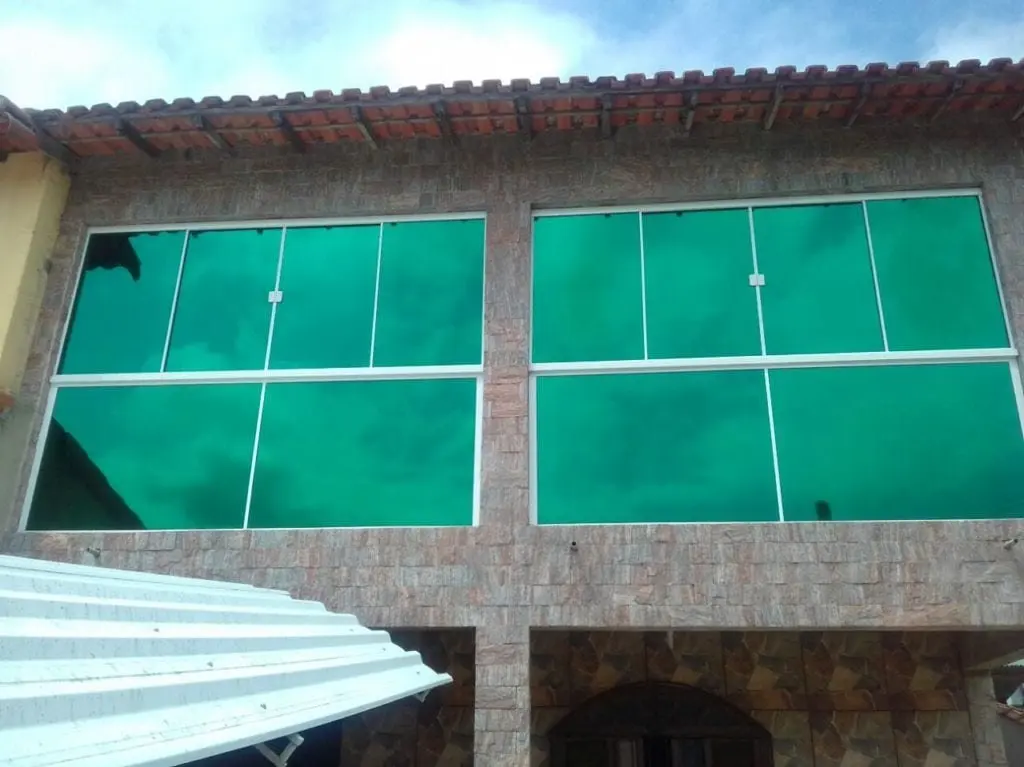 Película espelhada verde aplicada em fachada residencial