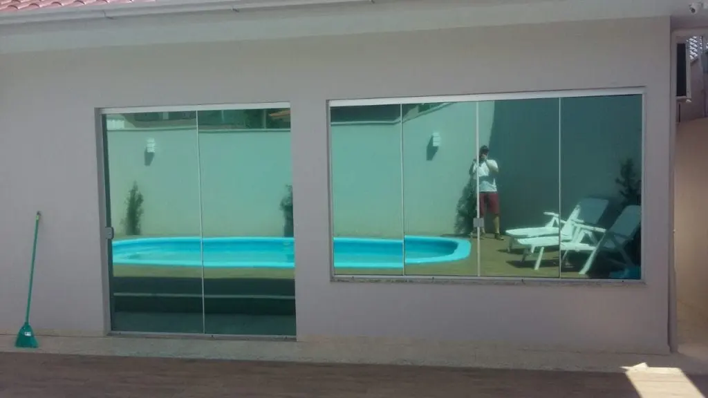 Película espelhada verde em fachada com piscina